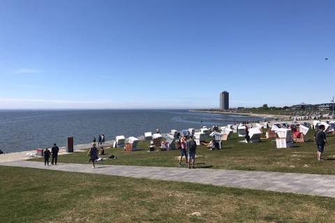 Deich mit Strandkörben bei blauem Himmel